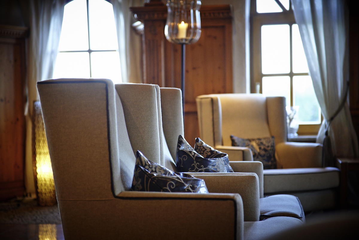 Gemütliche Sitzecke mit Sesseln in der Hotelbar bei Tageslicht.