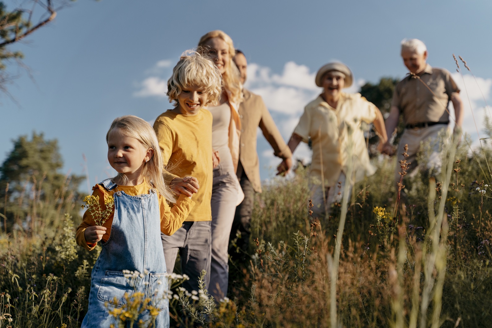 3 Generationen einer Familie laufen durch die Natur