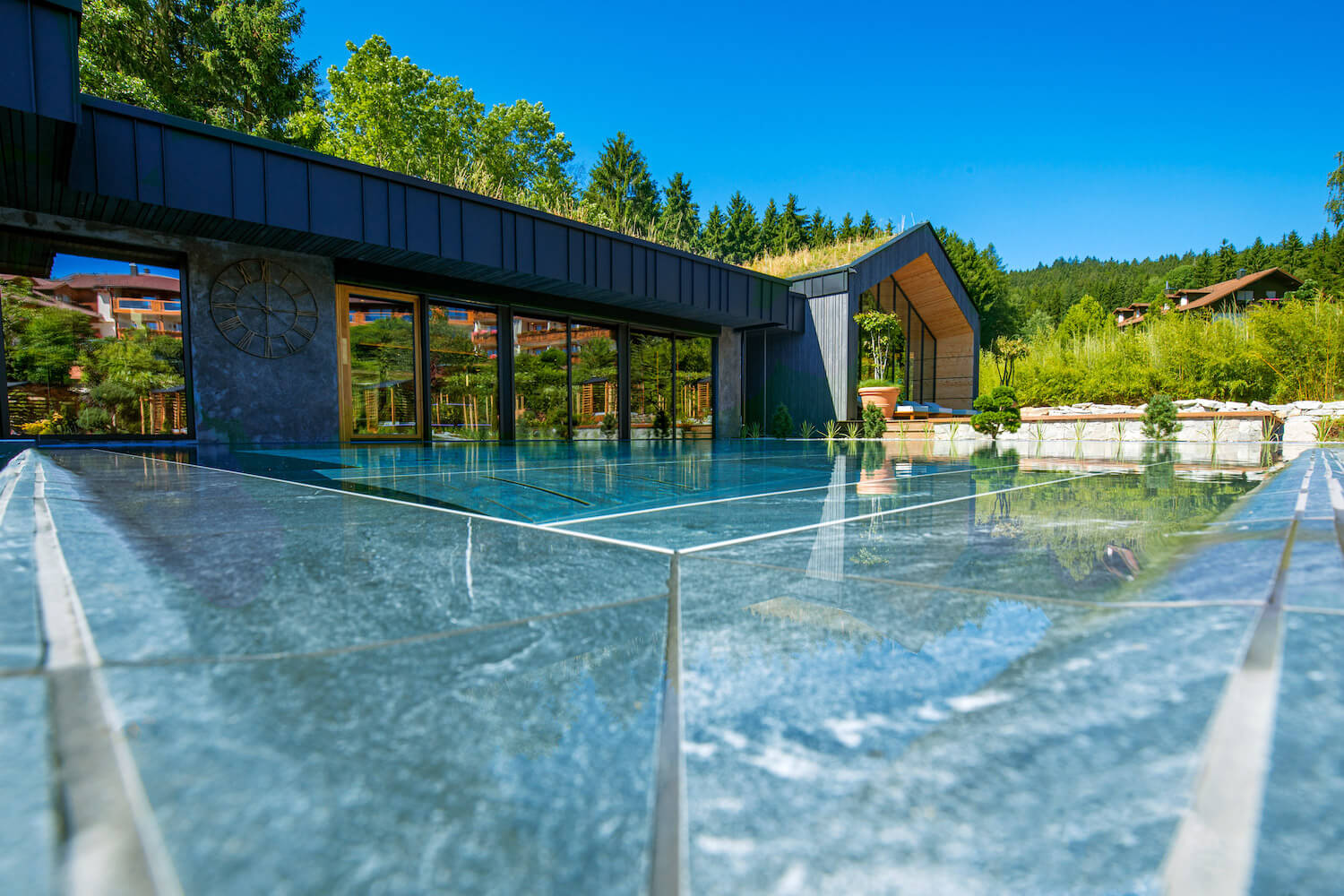 Modernes Solepool-Gebäude mit großen Glasfronten und Außenpool